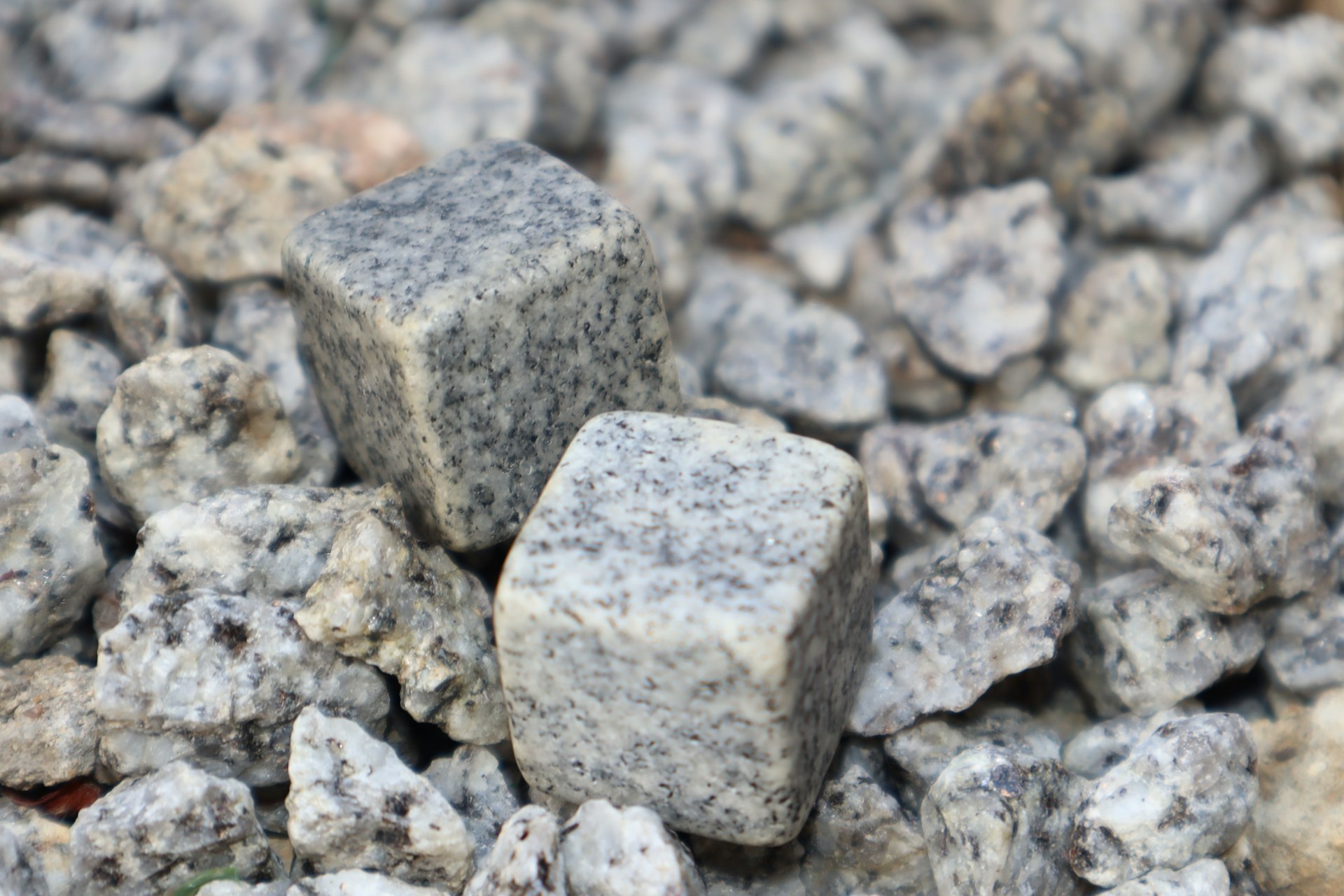 a pile of gray rocks with white speckles